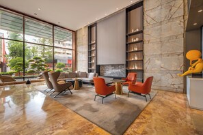 Een modern interieur met een zithoek, een open haard en een groot raam met uitzicht op een stadsgezicht.