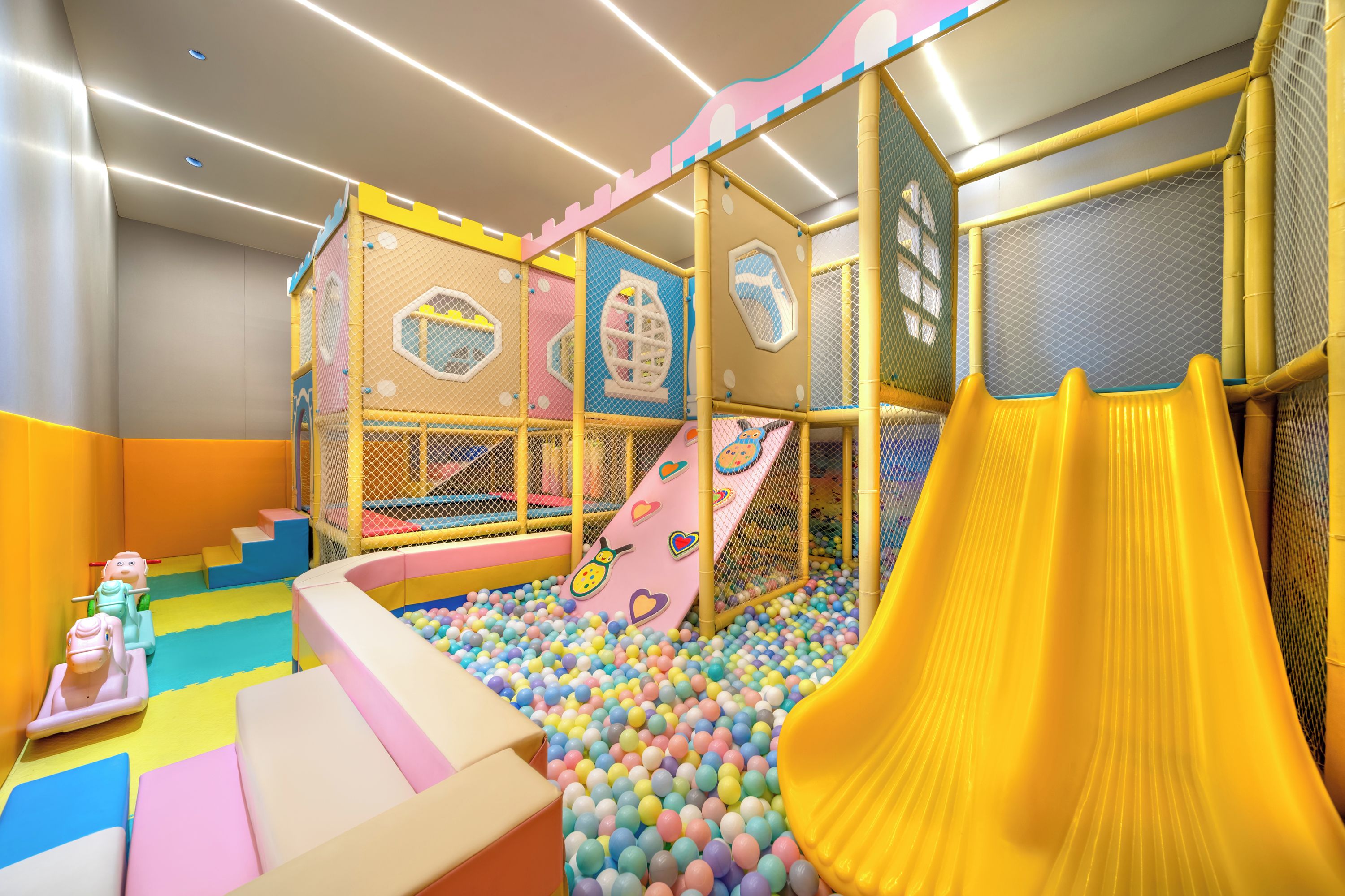 A children's play area with a ball pit, slides, and climbing structures.