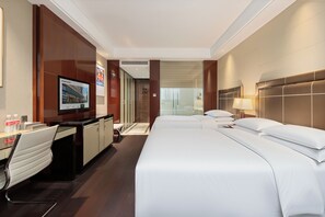 A hotel room with a bed, a desk, a chair, a television, and a bathroom. - Mai Xinge International Hotel  (Shanghai)