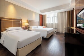 A hotel room with two beds, a desk, and a television. - Mai Xinge International Hotel  (Shanghai)