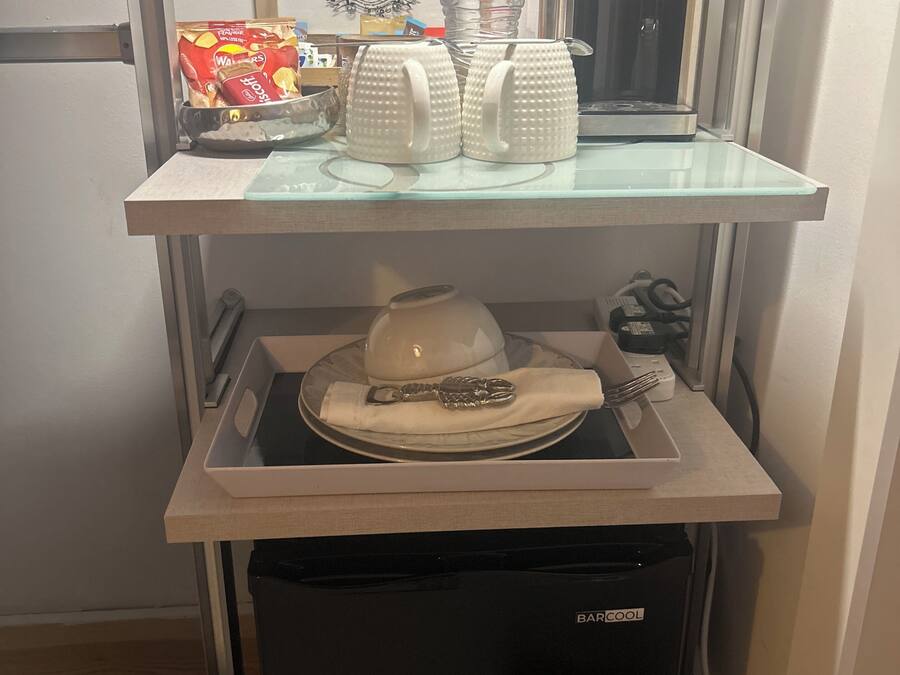 A compact kitchenette with a coffee maker, a water dispenser, and a microwave.