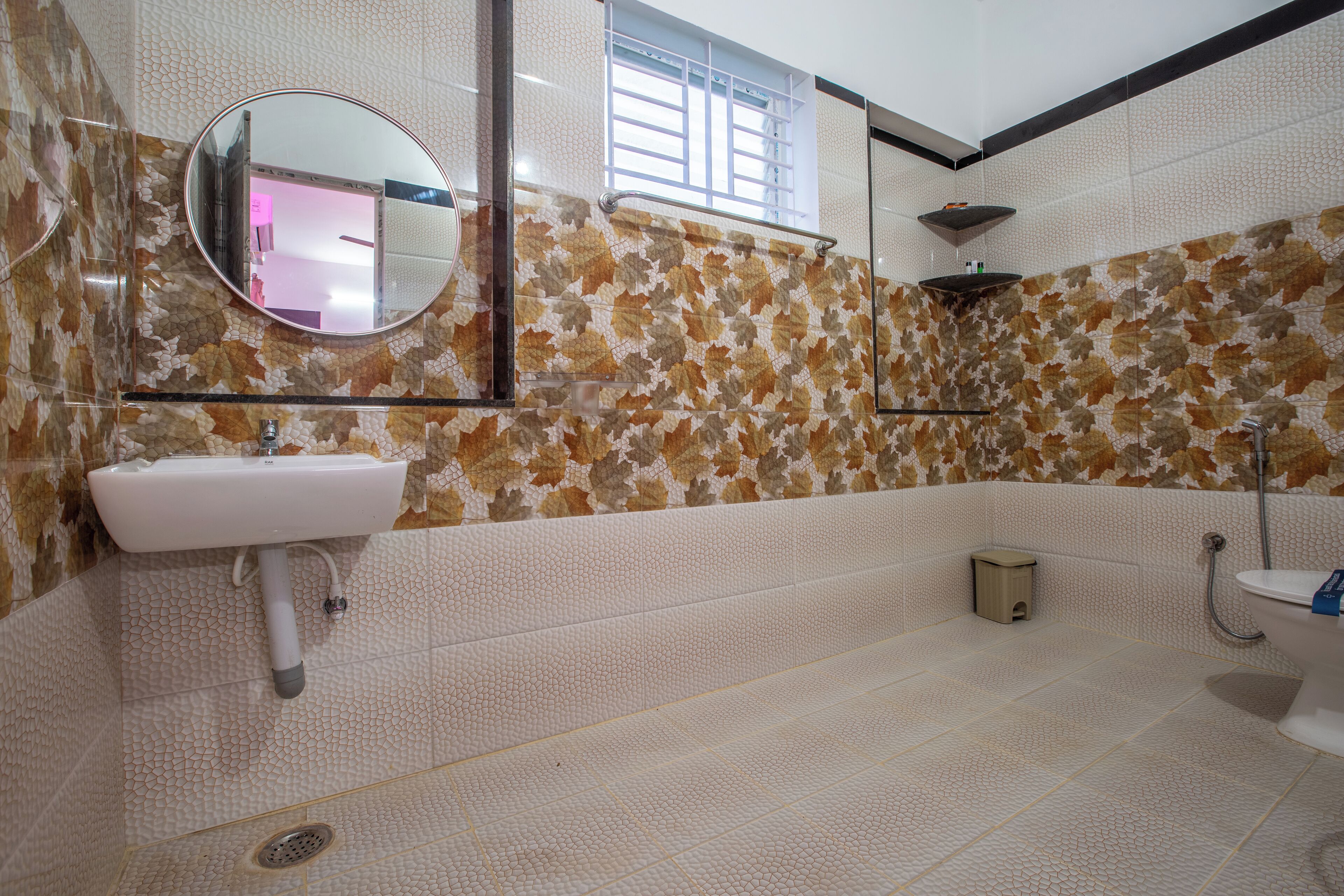 Ein Badezimmer mit Waschbecken, Spiegel, Dusche und Toilette.