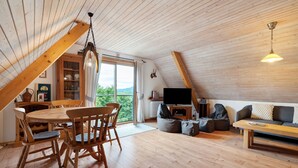 Un interior de madera con comedor, asientos y televisor.