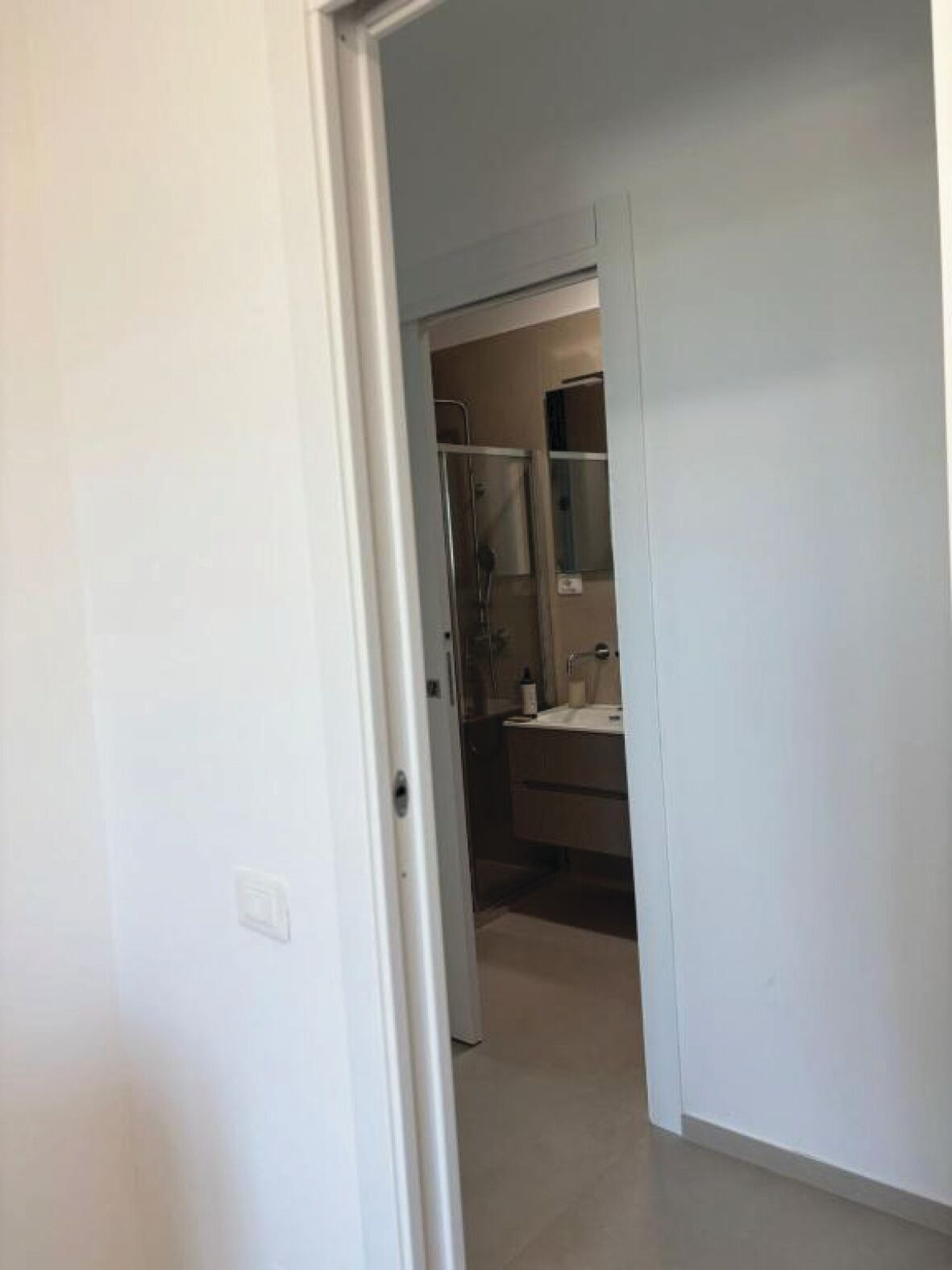 A bathroom with a shower, sink, and mirror.