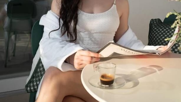 A person sitting at a table with a drink and a book. - Blu Arechi Camere di Charme - Salerno (Salerno)