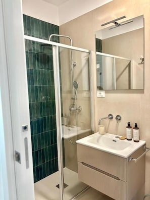 Double Room, Partial Sea View | Bathroom | Shower, hair dryer, slippers, towels