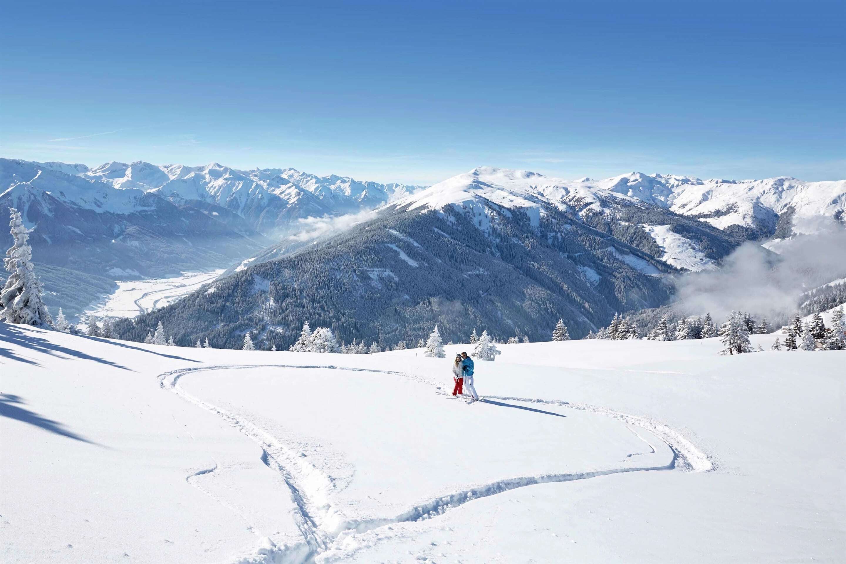 Un paysage de montagne enneigé, sous un ciel dégagé.