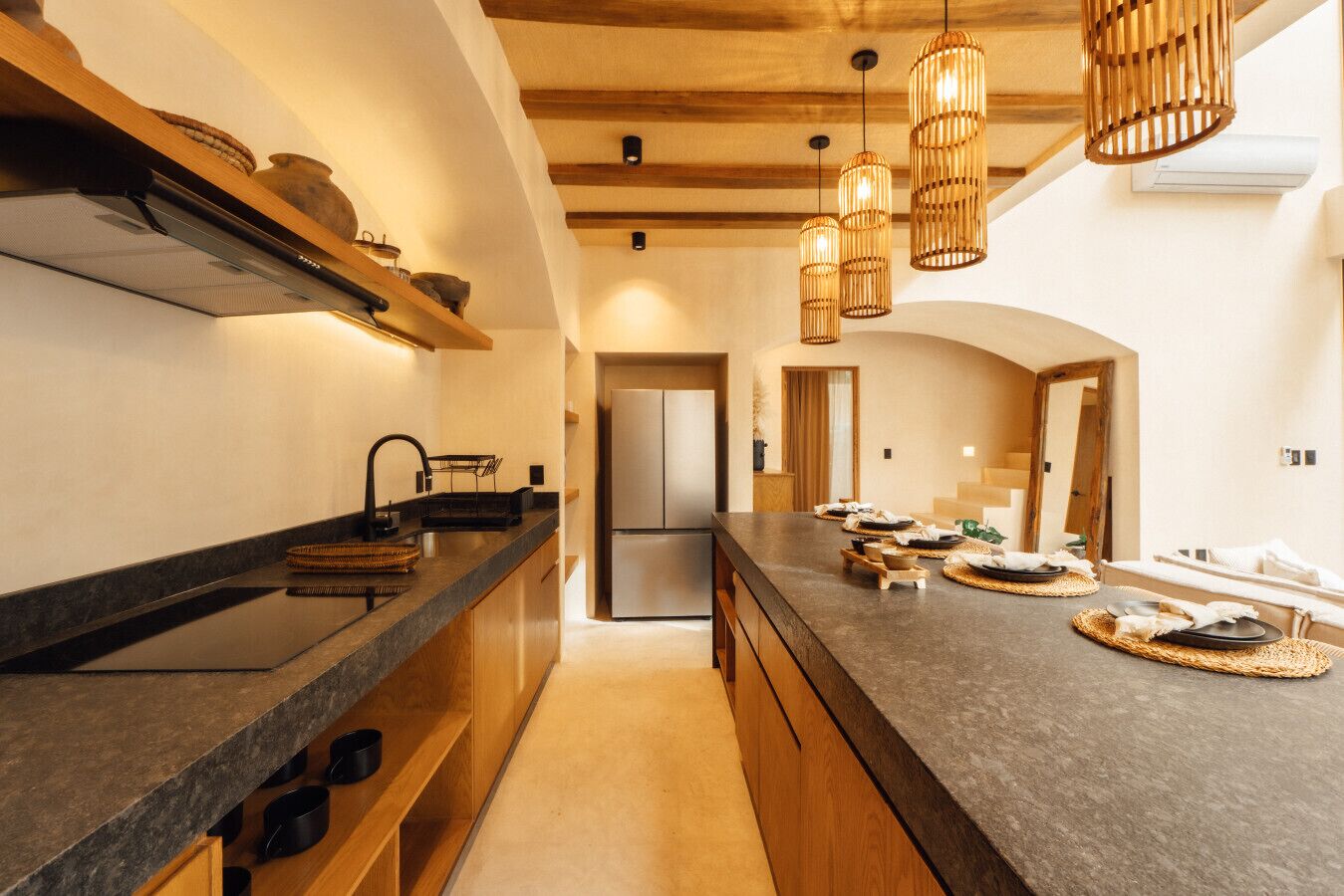 A modern kitchen with a long countertop, wooden cabinets, and a built-in oven.