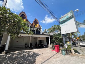 Un edificio con garaje, motocicletas estacionadas y un letrero.