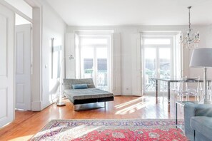 A bright room with a bed, a glass table, and a chandelier. - Eighteen21 Houses - Casa de São Paulo (Lisbon)
