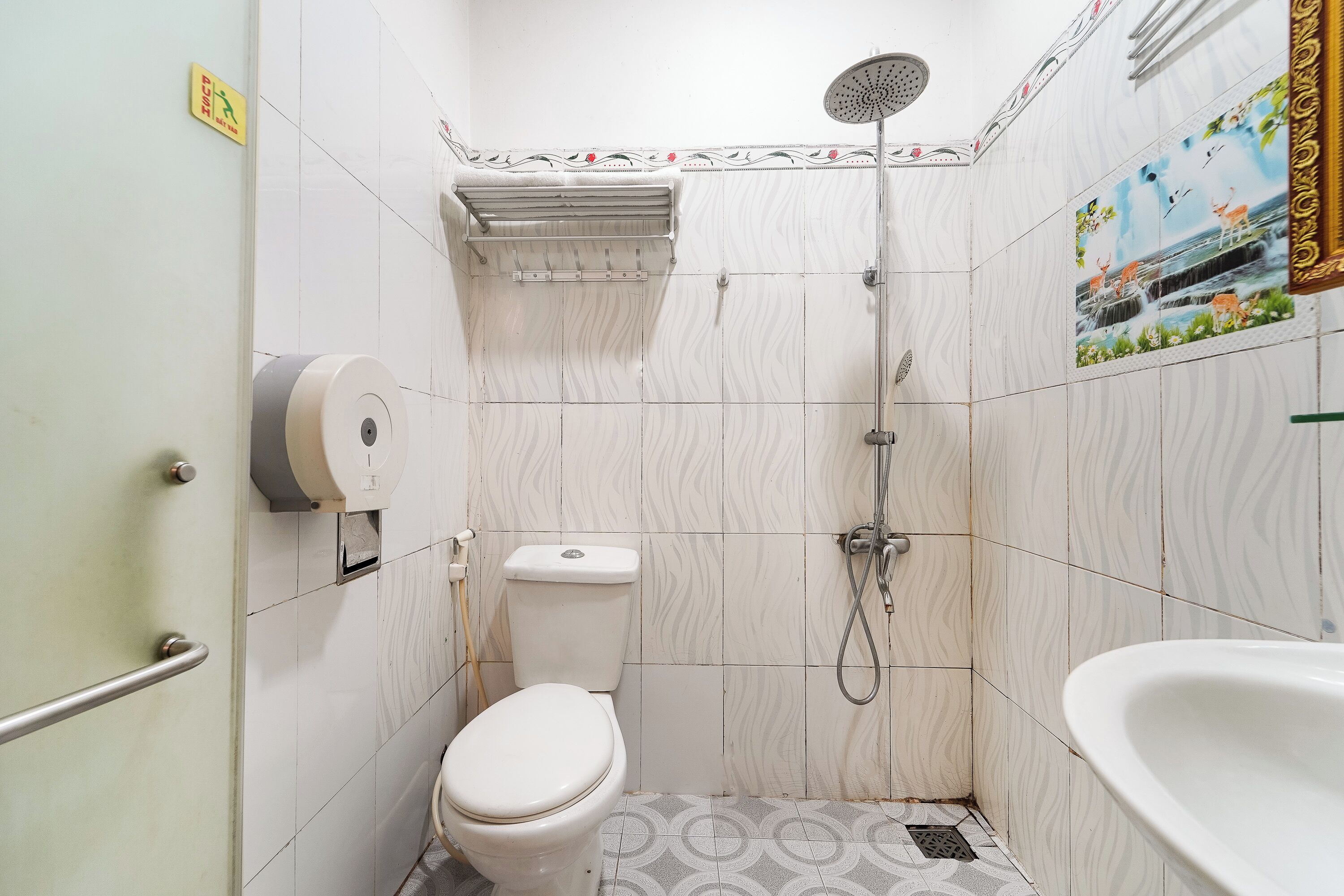A bathroom with a toilet, shower, and sink.