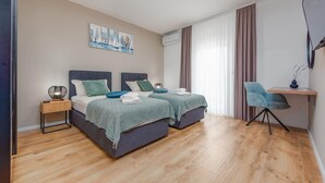 Une chambre moderne avec deux lits, un bureau et une chaise.