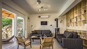 A modern living room with a sofa, chairs, a coffee table, and a bookshelf. - Family villa Keshi - not far from Tsilivi beach (Tragaki)