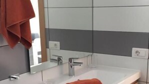 A modern bathroom with a white sink, wooden cabinet, and a towel on the counter. - Alsol Los Leones bungalows - Adults Only (San Bartolomé de Tirajana)
