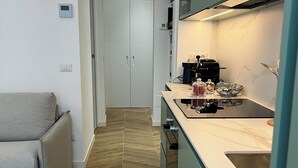 Una cocina moderna con piso de madera en espiga, horno empotrado y un lavamanos.