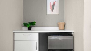 A compact kitchen with a white countertop, a built-in oven, and a small cabinet.