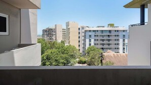 A view of a multi-story building with a flat roof and a balcony.