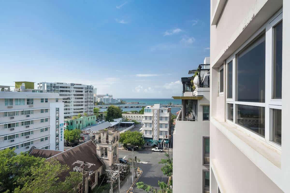 Un edificio alto con varios pisos, ventanas grandes y vista al mar.