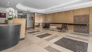 A modern reception area with a curved counter, seating, and decorative elements.