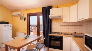 Apartamento, 2 quartos | Cozinha privada | Geladeira, micro-ondas, fogão, cooktop