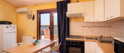 Una cocina compacta con comedor, estufa, horno y lavavajillas.