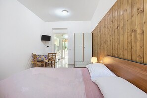 A bedroom with a bed, a wooden headboard, a desk with a chair, a television, and a lamp. - Studio 'Sabbia D'oro' with Shared Pool and Wi-Fi (Scialara)