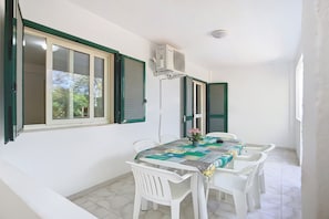 Un espace repas comprenant une table, des chaises et un appareil de climatisation.