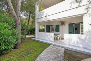 Una casa moderna de dos pisos con un porche cubierto, un pequeño jardín y vistas al entorno verde.
