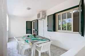 Un espace repas comprenant une table, des chaises et un appareil de climatisation.