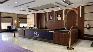 A hotel reception area with a marble counter, a reception desk, and a fire extinguisher mounted on the wall. - Wefaq Al-Mashaer Hotel (Makkah)