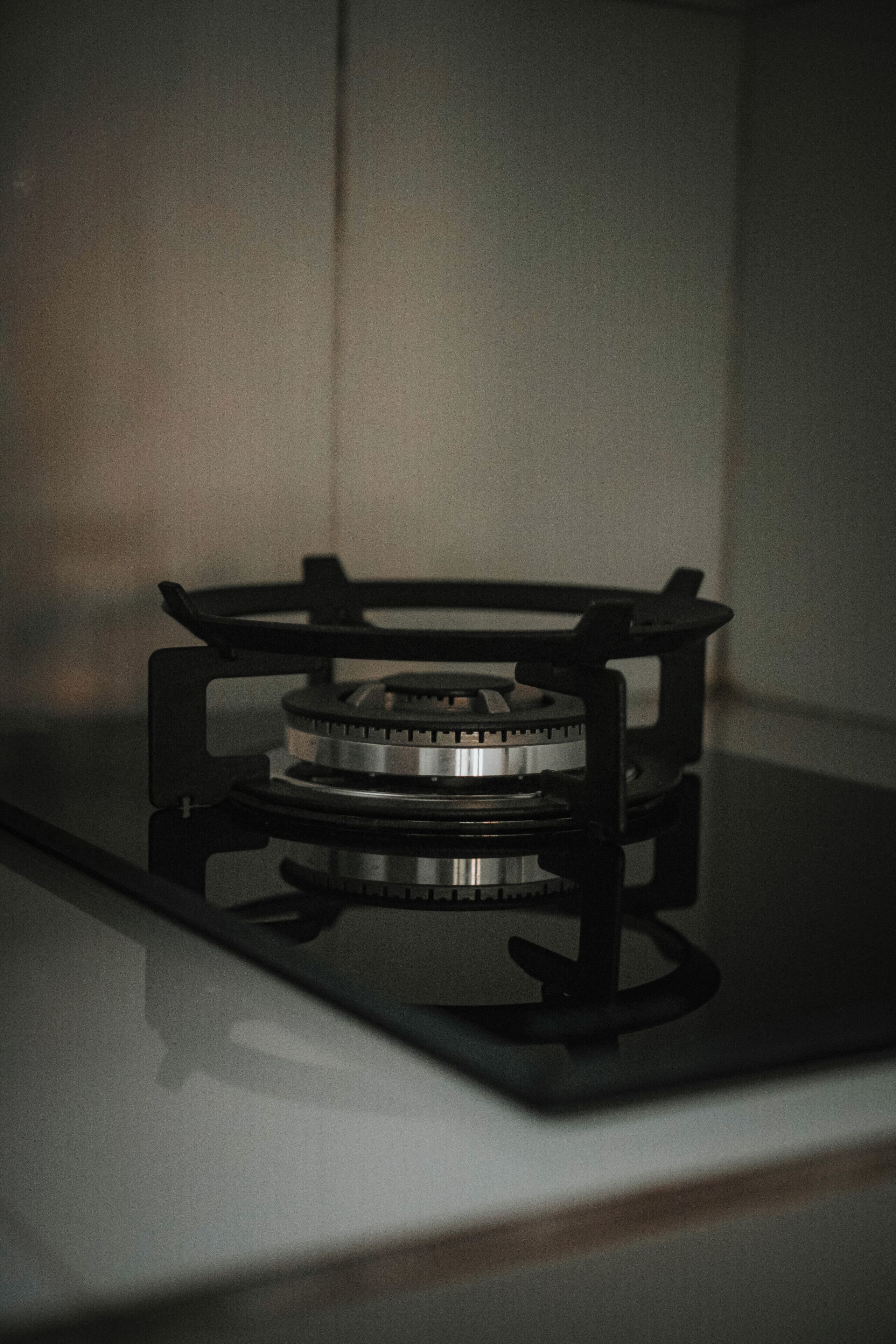 A gas stove with a black frame and a metallic burner.