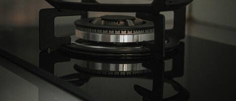 A gas stove with a black frame and a metallic burner.