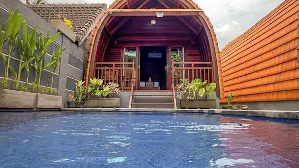 A building with a red roof and a pool in front. - Sayong Wooden House (Ubud)