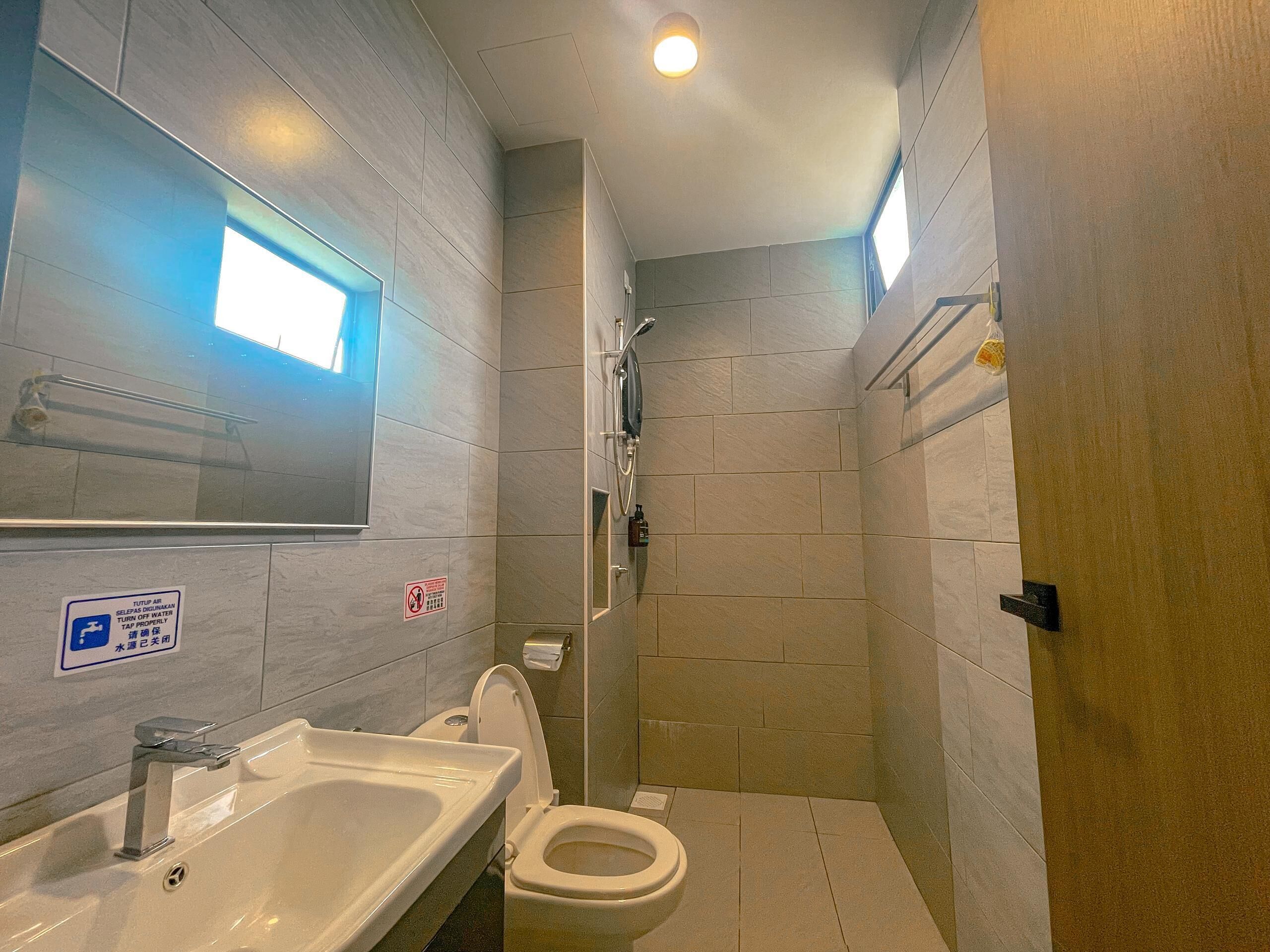 Un baño pequeño con lavamanos, inodoro y ducha.