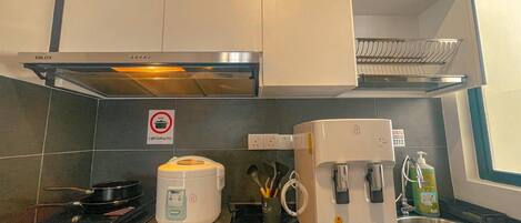 Een koelkast, een microgolfoven, een kookplaat, een kinderstoel