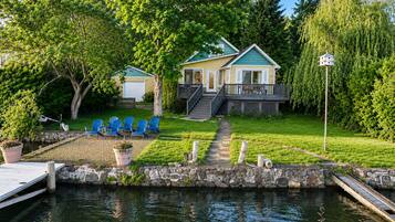A lakeside property with a dock, a stone pathway, and a small docked boat.
