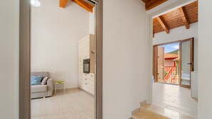 A modern interior with a kitchen, a dining area, and a staircase leading to an outdoor area. - Apartment 'Maria Rosa' with Private Terrace, Wi-Fi and Air Conditioning (Teulada)