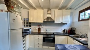 A compact kitchen with white cabinets, a stainless steel range hood, a microwave, and a coffee maker. - 🏡 Chez Tata - Authentic vacation home in the heart of Le Crotoy (Le Crotoy)