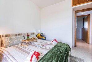 Un dormitorio ordenado con cama, mesita de noche y lámpara.