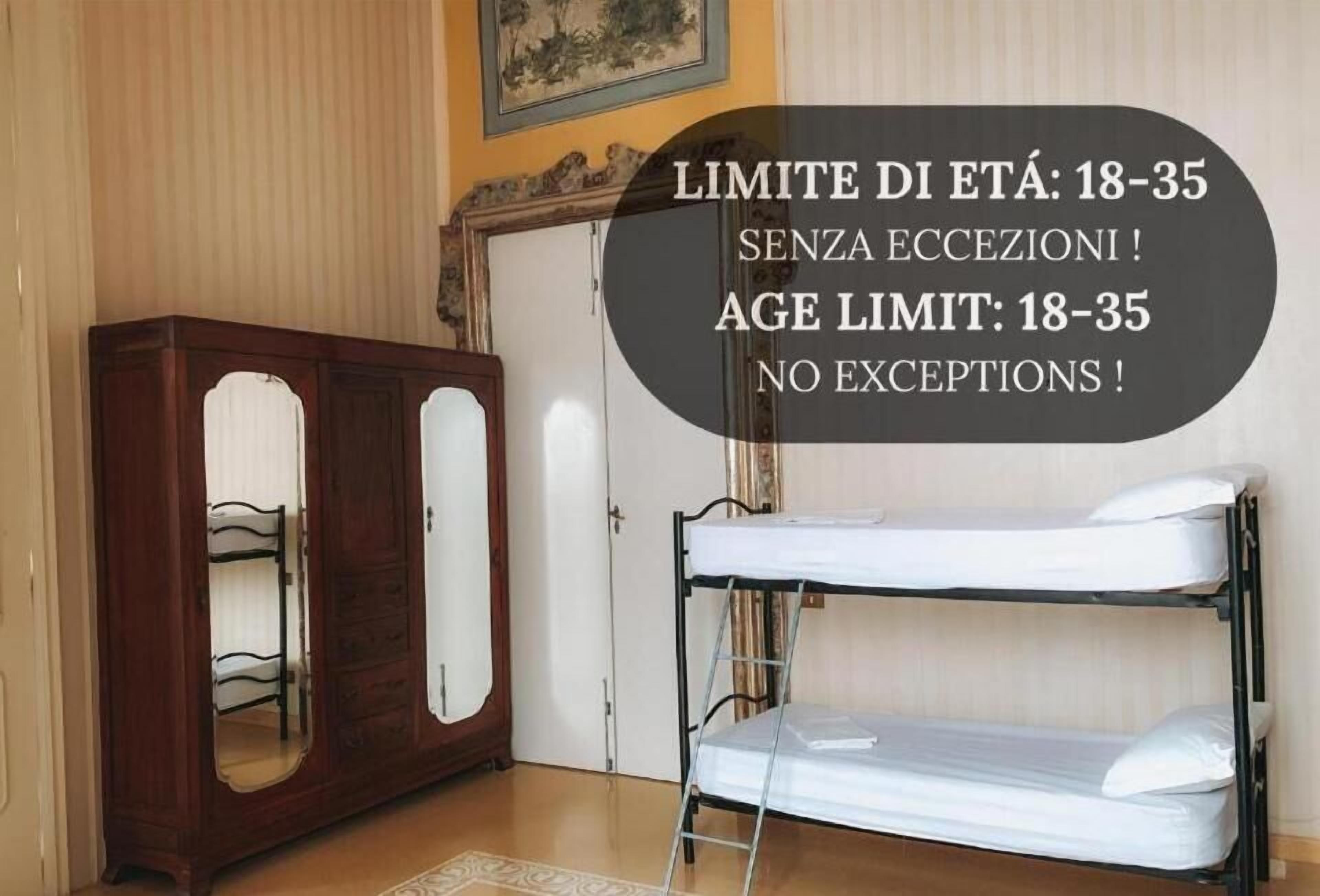 A room with a bunk bed, wooden wardrobe, and a mirror.