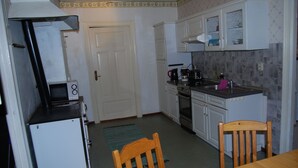 A compact kitchen with white cabinets, a refrigerator, a coffee maker, and a sink. - Malaskog nature reserve Baden (Malaskog)