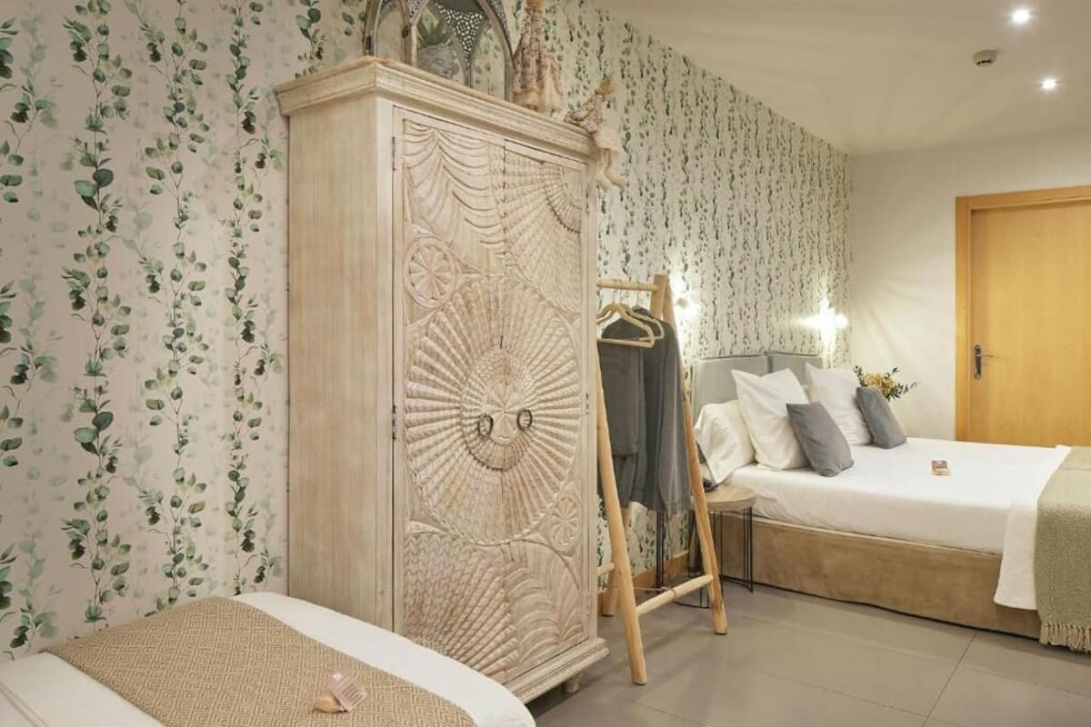 A bedroom with a bed, a wardrobe, and a mirror.