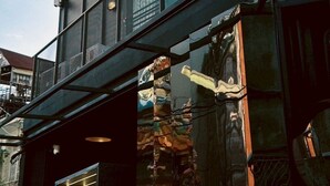 Un bâtiment moderne doté d’une façade en verre, d’une section de façade en pierre et d’une structure métallique.
