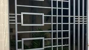 Un edificio con una reja metálica y una ventana con diseño geométrico.