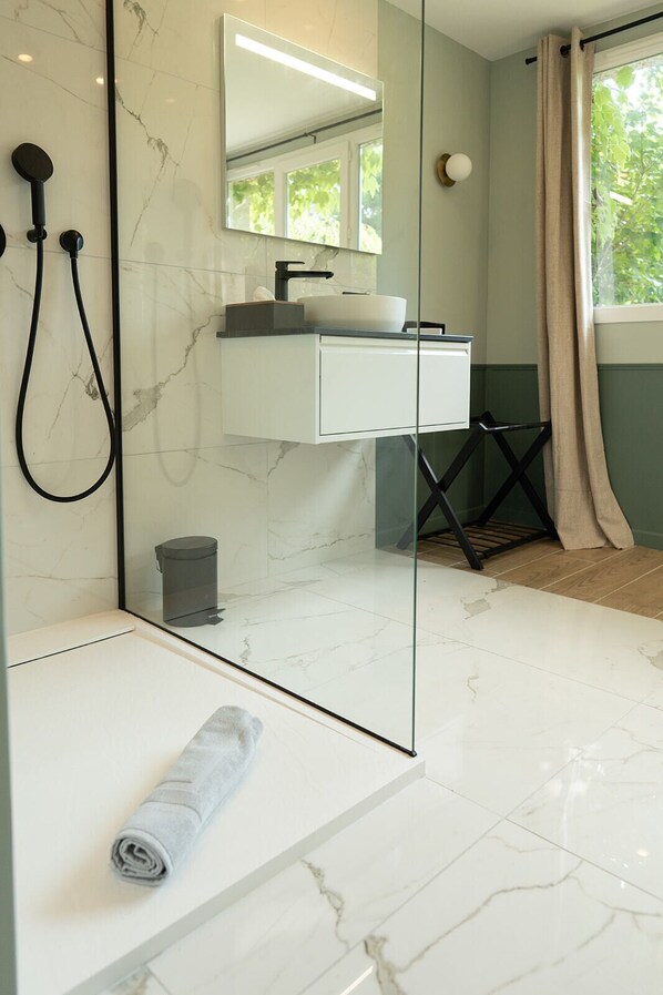 A modern bathroom with a glass shower enclosure, a white sink, and a large mirror. - Le Clos du Château (Amboise)