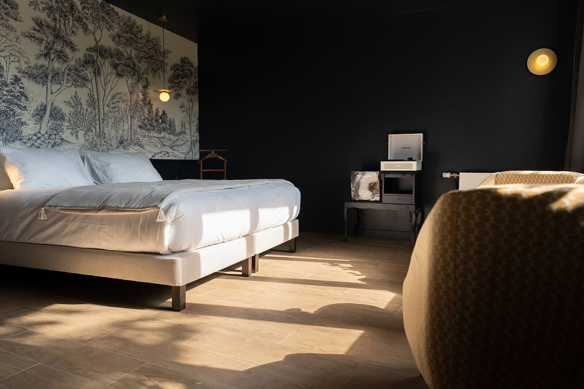 A modern bedroom with a bed, bedside table, and a chair.