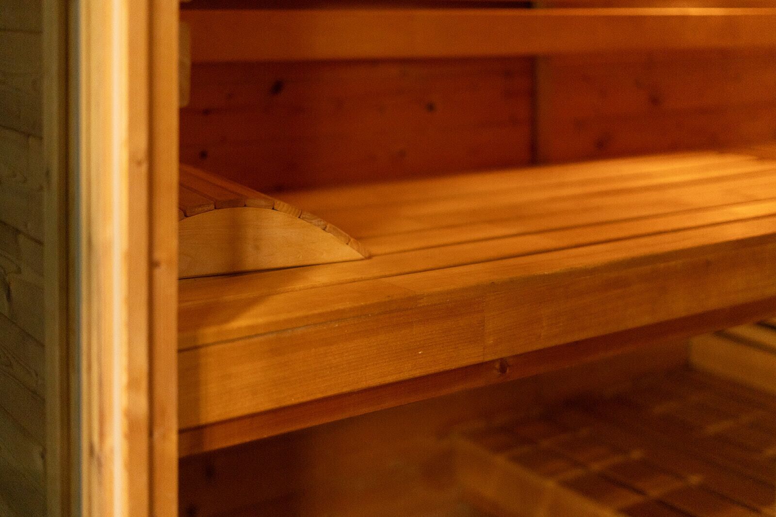 A wooden bench with a curved backrest, likely part of a public space or waiting area.