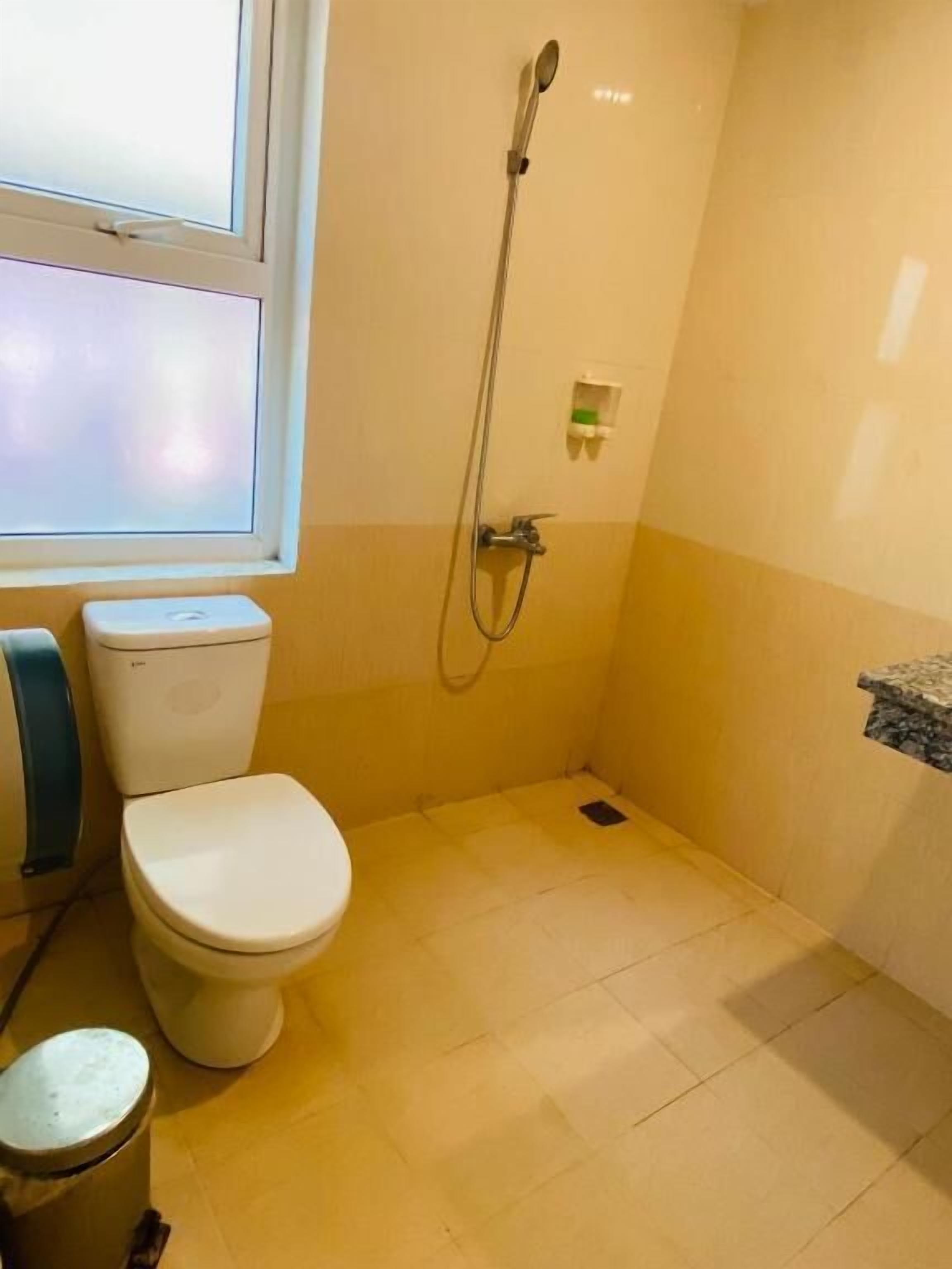A small bathroom with a toilet, a shower, and a sink.