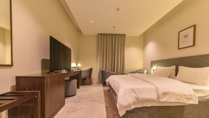 A hotel room with a bed, a desk with a computer, a chair, and a TV. - Marsal Park Hotel (Riyadh)