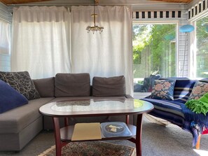 A cozy living room with a sofa, a round table, and a patterned rug. - 4 Star Holiday Home in Hollviken (Hollviken)